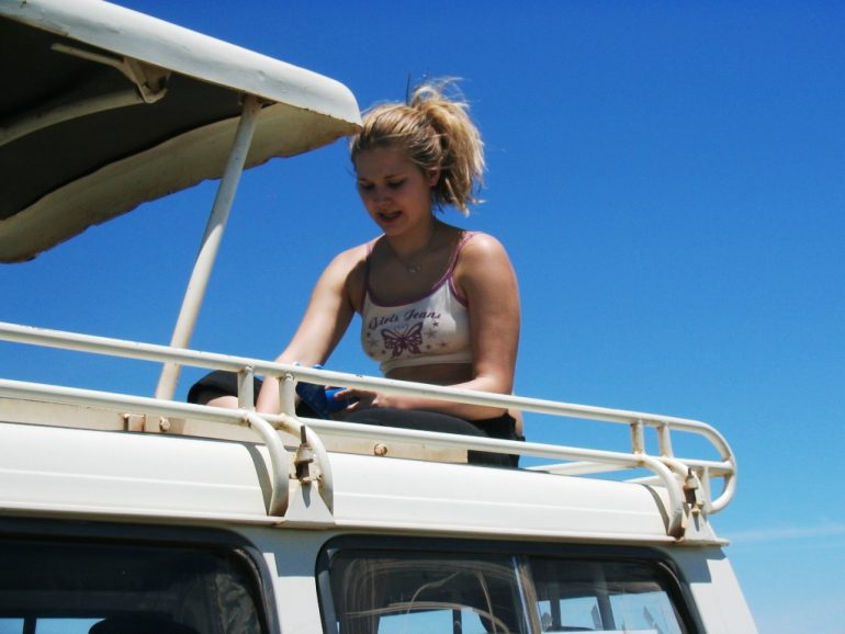 Safarimatkaaja auton katolla Tansania